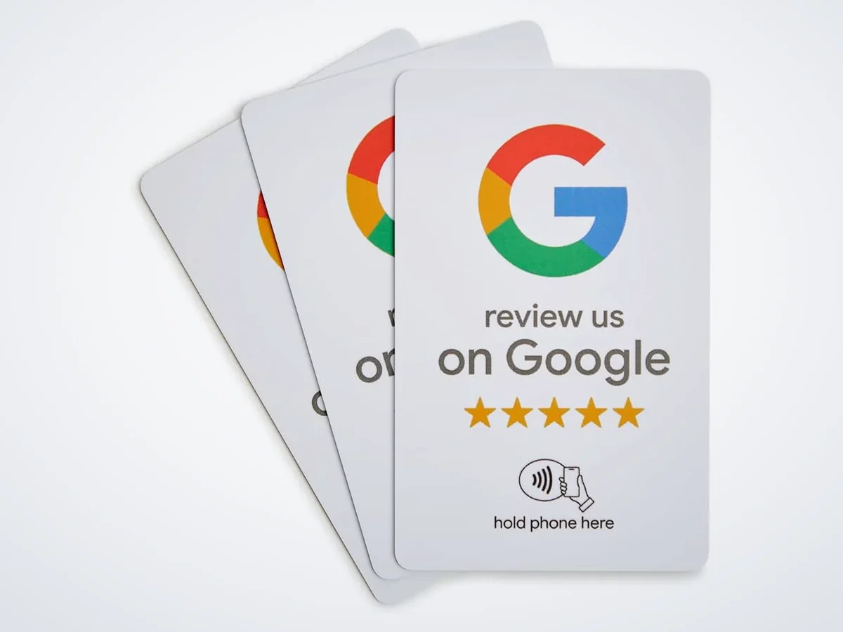 Three white Google review NFC cards reading review us on Google, with five stars and a hold phone here symbol